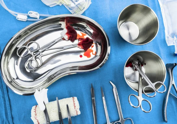 Tijeras quirúrgicas con torundas empapadas de sangre en una bandeja metálica en un quirófano, composición horizontal, imagen conceptual — Foto de Stock