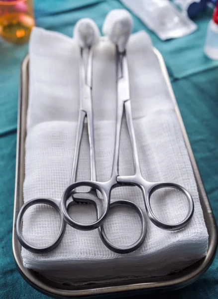Tijeras quirúrgicas con torundas sobre una bandeja metálica en un quirófano, imagen conceptual —  Fotos de Stock