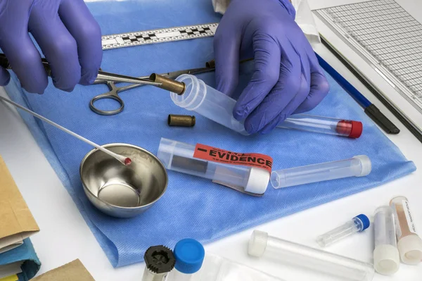 Scientific police picking up bullet cap with tweezers, conceptual image, horizontal composition — Stock Photo, Image