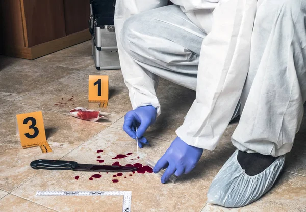 Polizei entnimmt Blutprobe aus einem Blutmesser am Tatort — Stockfoto