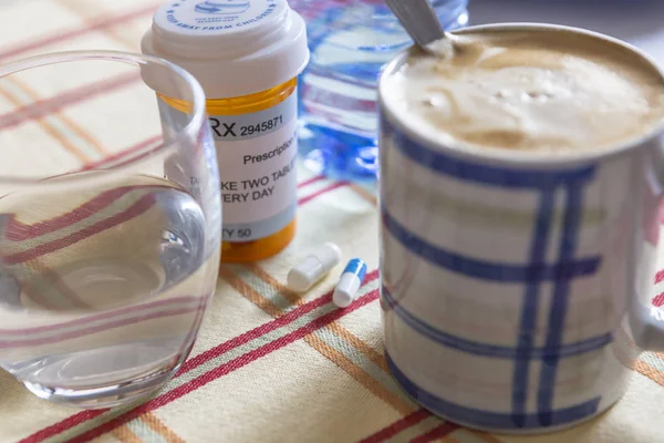 Kahvaltı sırasında ilaçlar, bir bardak suyun yanında kapsüller, kavramsal görüntü, yatay bileşim — Stok fotoğraf