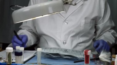 Balistik Laboratuvarı'nda mermi kapağını inceleyen bilimsel polis 