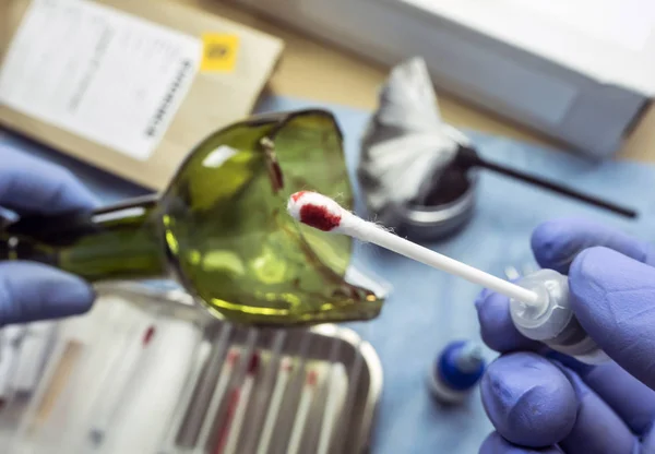 Polizei-Experte bekommt Blutprobe aus zerbrochener Glasflasche im Criminalistic Lab — Stockfoto