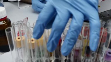 Kriminolojik polis memuru laboratuvarda analiz edilecek kan örneği ile makas ile hyssop keser