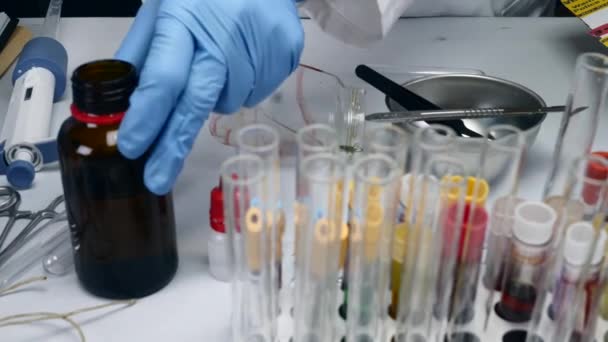 犯罪学的な警察官は 実験室で分析される血液サンプルでハサミのヒソップでカット — ストック動画