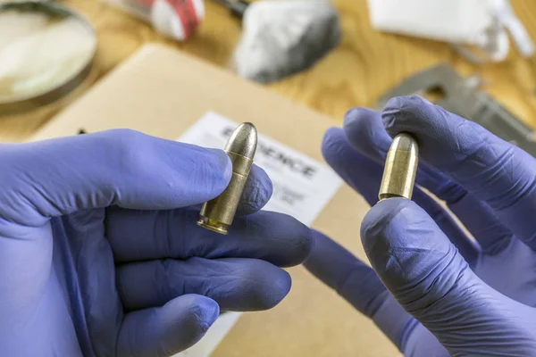 Police expert compares two bullets of different caliber in laboratory scientist — Stock Photo, Image