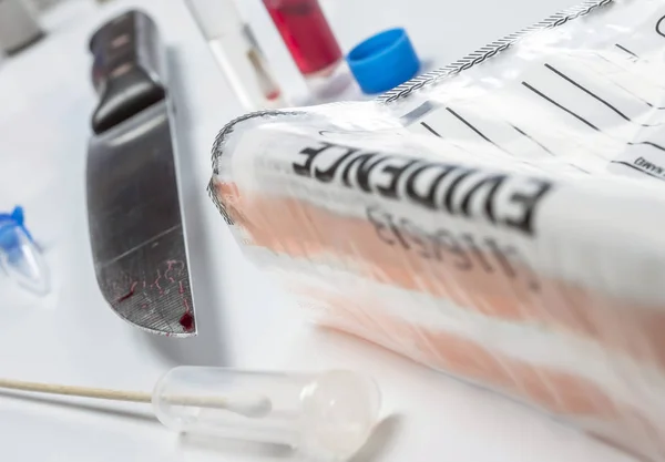 knife Spotted with blood along with a evidence bag in scientific laboratory, conceptual image