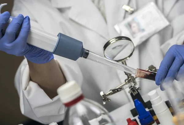 Policiais especializados pegando mostra sangue em detentor de microscópio para analisar em laboratório científico, imagem conceitual — Fotografia de Stock