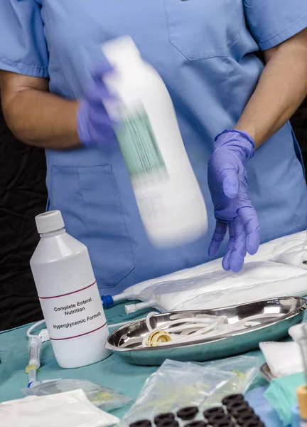 Enfermera agitando botella enteral de Nutrición en un hospital, Cuidados Paliativos, Imagen Conceptual — Foto de Stock