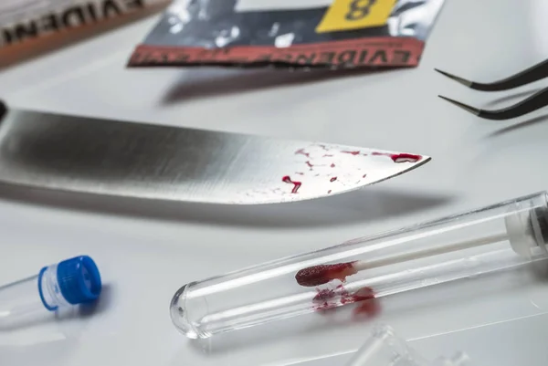 Нож замечен с кровью вместе с мешком для улик в научной лаборатории, концептуальное изображение — стоковое фото
