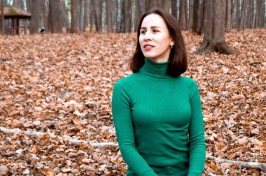girl sitting on the background of autumn leaves
