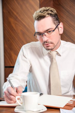 masanın arkasında Müdürü / Yöneticisi sabit ofiste masanın arkasında veriler üzerinde çalışma.