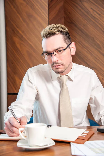 masanın arkasında Müdürü / Yöneticisi sabit ofiste masanın arkasında veriler üzerinde çalışma.