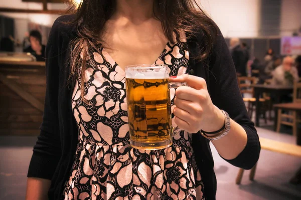ビールを飲みながら若い女性が飲み物を持っていて — ストック写真