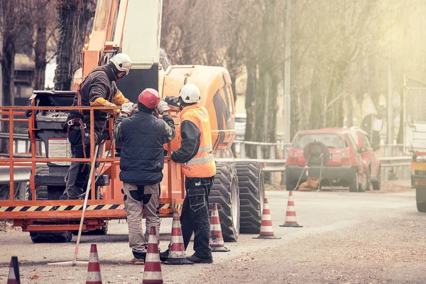 在公路上工作的工人 一组在机器旁工作的人 右边有复印机的空间 — 图库照片