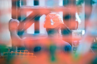 Kaza önleme işçisi, inşaat güvenliği konsepti - inşaat sahasının arkasında miğferi olan işçi