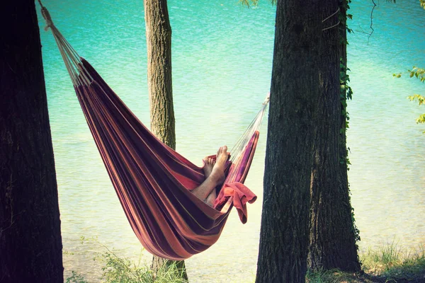hammock near the water, relax of a person during the holidays on the shore of a lake/sea