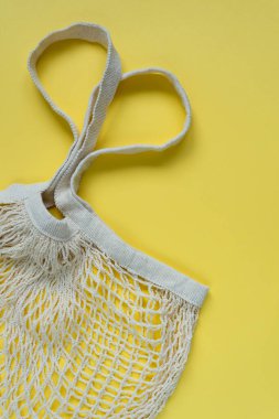 Sarı arka planda örülmüş ip torbası. Kalp şeklinde saplar.