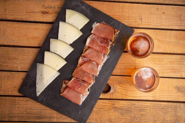 beer and cheese and serrano ham board from spain