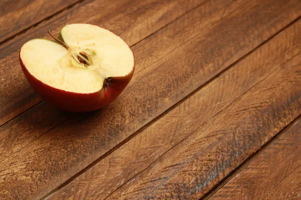 red apple cut in half on wooden background