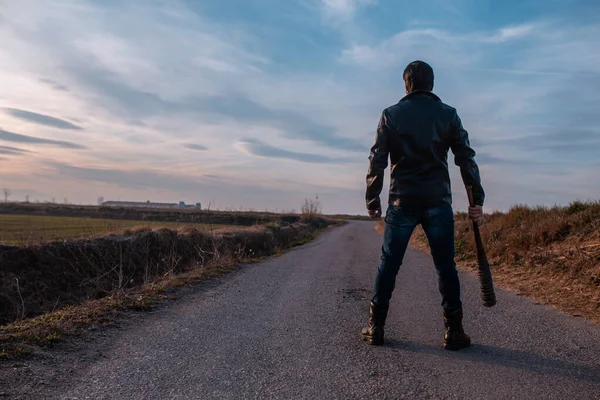 man in leather jacket and baseball bat