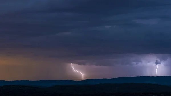 Breathtaking view of powerful thunderstorm over hills in evening