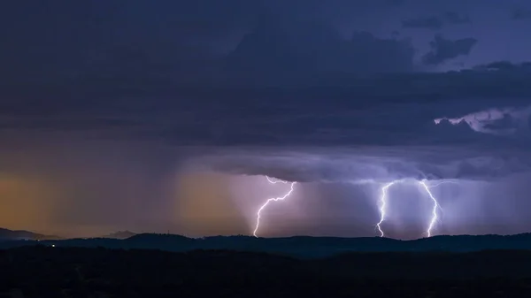 Breathtaking view of powerful thunderstorm over hills in evening