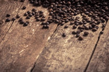 Ahşap masa arka plan üzerine dökülen taze kahve çekirdekleri yakın çekim görünümünü