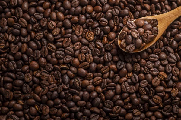 Cucchiaio di legno con chicchi di caffè tostati — Foto Stock