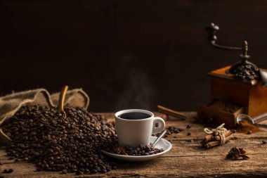 Kahve çekirdekleri fincan hoş kokulu kahve ve kahve değirmeni ahşap tablo siyah arka plan üzerine beyaz