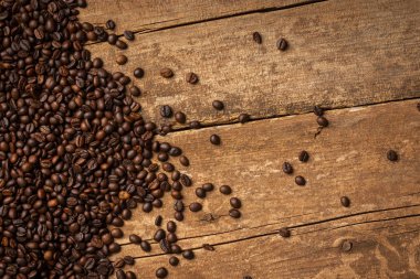 Ahşap masa arka plan üzerine dökülen taze kahve çekirdekleri yakın çekim görünümünü