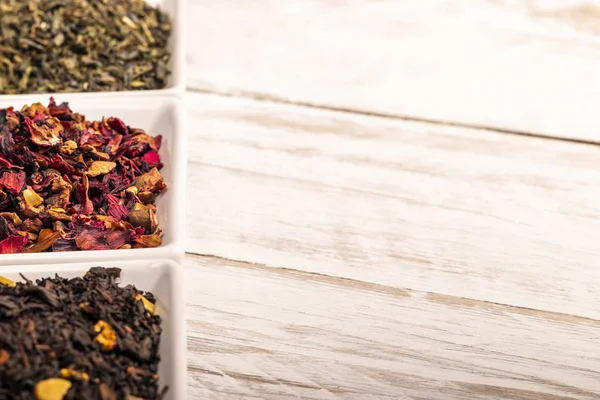 Beyaz kaşık toz kuru çay yaprak görünümünü yakın çekim ayakta beyaz ahşap tablo satırındaki