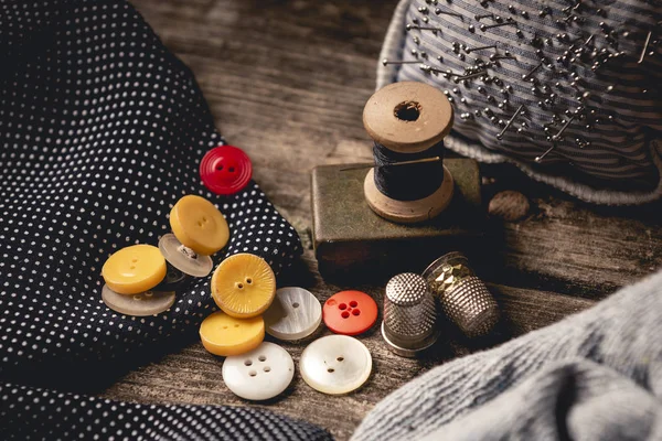 다채로운 버튼의 클로즈업 헝겊과 쿠션의 조각으로 테이블에 Thimbles와 바느질 흩어져 — 스톡 사진