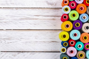 Güzel dikiş biriktiricileri parlak canlı konu ile yukarıdan beyaz sert ahşap tahta masada yer