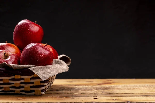 黒い背景に編みこみボールで横になっている濡れている赤いリンゴの束 — ストック写真