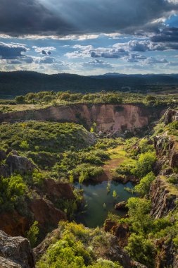 Güzel yeşil vadi yeşil tepeler ve bulutlu gün Cerro del Hierro, Seviile içinde küçük bir göl ile pitoresk havadan görünümü