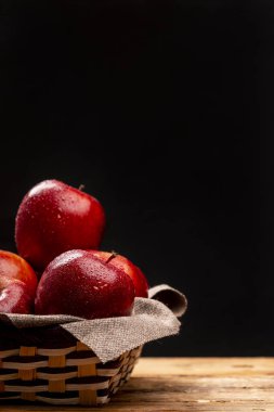 Grup siyah arka plan üzerine örgülü kabın içinde yalan ıslak kırmızı elma
