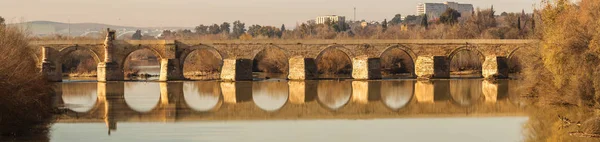 Antiguo puente romano de piedra sobre el río Guadalquivir a la luz del sol en —  Fotos de Stock