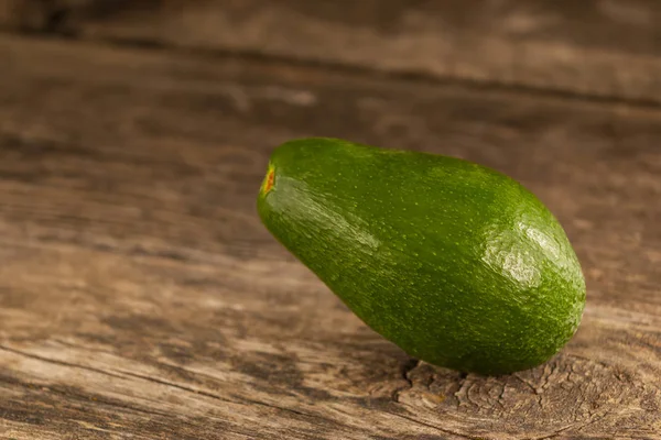 Błyszczący zielony awokado na drewno — Zdjęcie stockowe