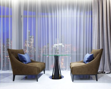 Bir tablo ile çağdaş salon restoranda iki rahat koltuklar. Akşam aydınlatma ile büyük pencereler ile ışıklı rahat alanı. 3D render