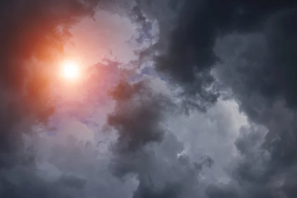 Epic cumulus storm grey clouds background with sun and sunlight