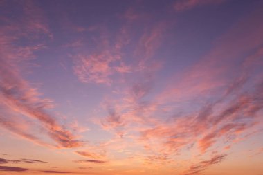 Dramatic soft sunrise, sunset. Beautiful pink violet orange clouds against blue sky background texture clipart