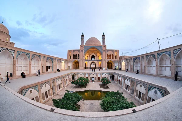 Kashan, İran - 4 Mayıs 2019: Mavi saatte Ağa Bozorg Camii 'nin manzarasının keyfini çıkaran insanlar