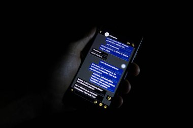 Torino, Italy- 10 Ekim 2019: Elinde bir telefon tutan kişi Whatapp 'ın karanlık modunu gösteriyor, popüler mesaj uygulaması.