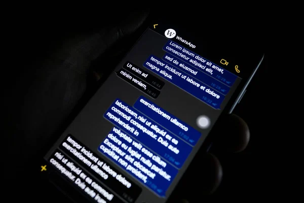 Torino, Italy- 10 Ekim 2019: Elinde bir telefon tutan kişi Whatapp 'ın karanlık modunu gösteriyor, popüler mesaj uygulaması.