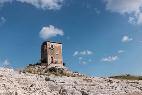 Siracusa, Sicilya, İtalya - 8 Aralık 2019: Siracusa Yunan tiyatrosunun arka planı ve mavi gökyüzü gibi koltukları olan Galerme yel değirmeni