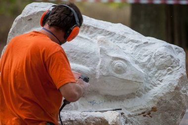 Bir adamın elinde testereyle çalışan bir işçi