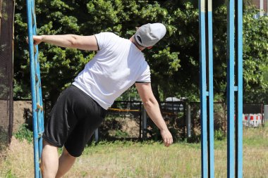 Yatay bardaki genç adam güneşli, doğada yaz havası. Kopyalama alanı - spor konsepti, karantina, sosyal uzaklık, yalnızlık, sağlıklı yaşam tarzı