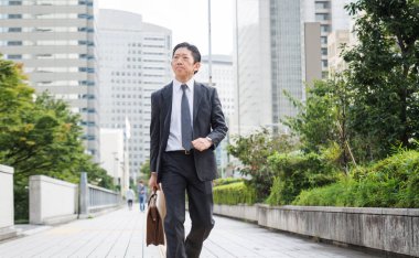Japon işadamı yürüyüş açık havada - Asya adam şık takım elbise