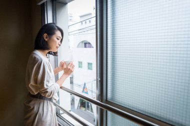 Geleneksel bir Tokyo dairede oturan ve bir fincan çay içme Japon kadın